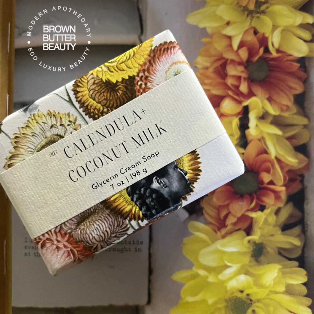 Coconut milk calendula soap bar wrapped in handmade paper featuring a vintage beauty ad photo, highlighting the artisanal quality of this natural skincare product. This coconut milk and calendula soap offers a moisturizing, soothing cleanse, ideal for those seeking unique, handcrafted soap with botanical ingredients and a nostalgic, vintage-inspired design