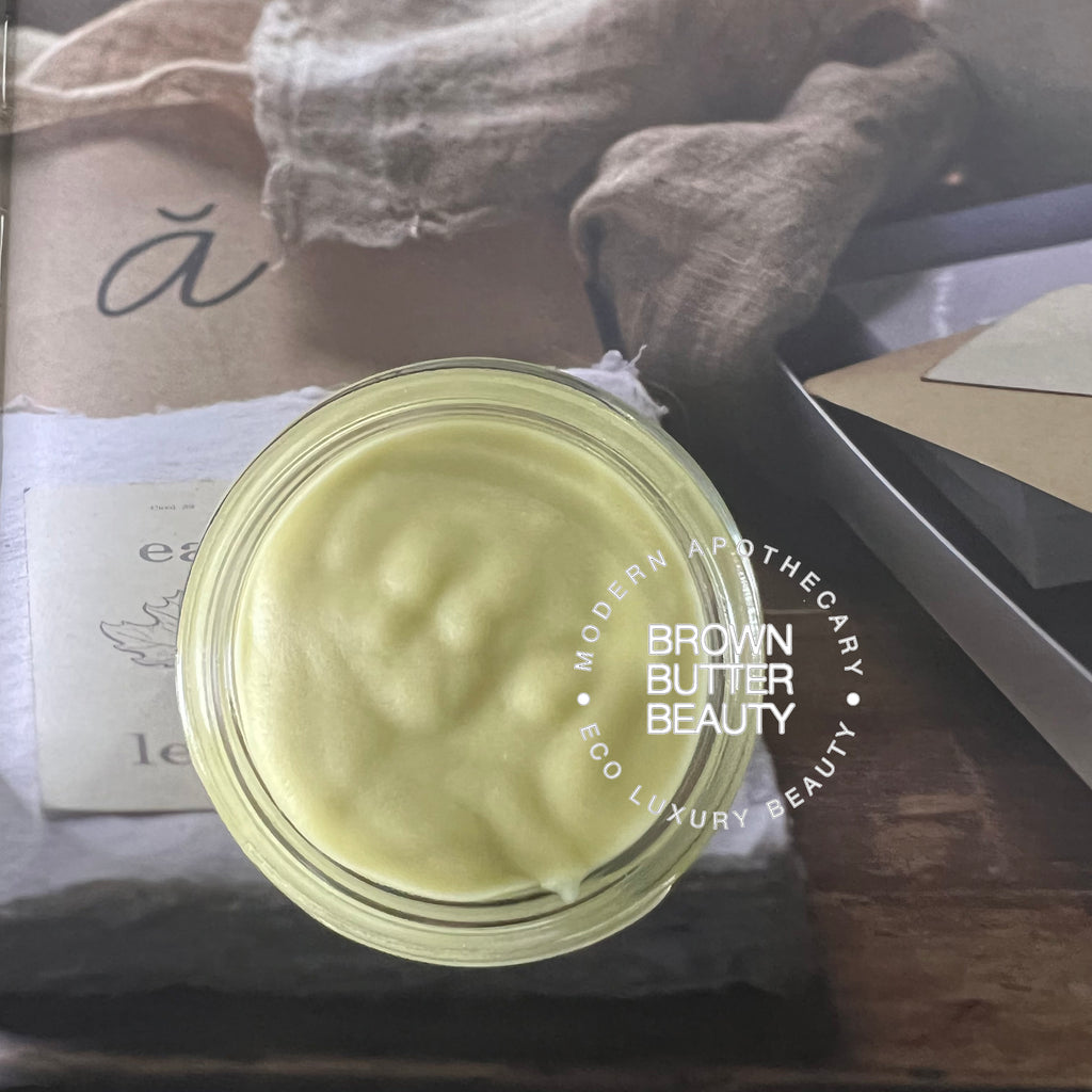 Handmade pumpkin seed butter surrounded by organic ingredients like organic pumpkin seed oil, organic shea butter, and coconut oil, showcasing its natural, artisan, and small-batch qualities for healthy skin.